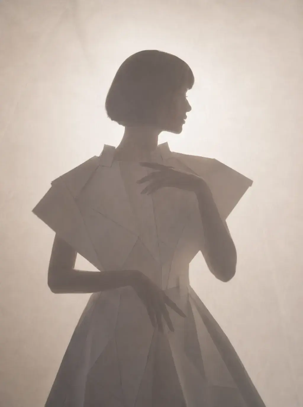 Silhouette féminine en robe blanche sculptée – atmosphère brumeuse et lumière diffuse