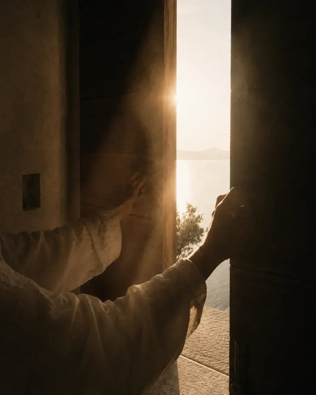 Silhouette féminine ouvrant une porte en contre-jour – coucher de soleil et mer