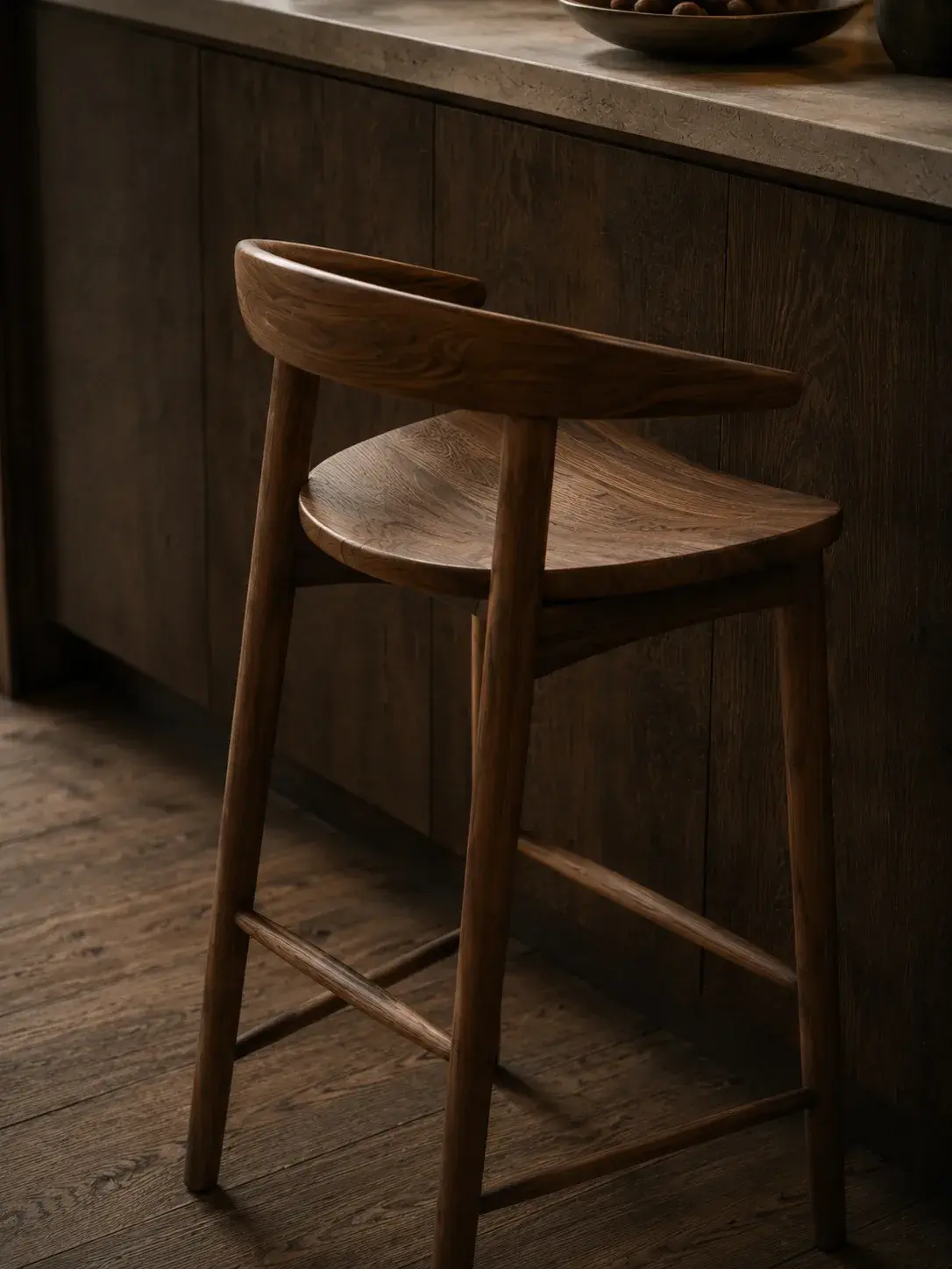 Tabouret de bar en bois tourné avec assise ronde et pieds effilés sur fond neutre clair