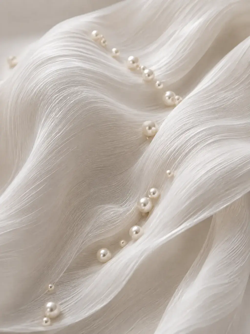 Tissu plissé ivoire en gros plan avec perles de tailles variées posées dans les creux des ondulations