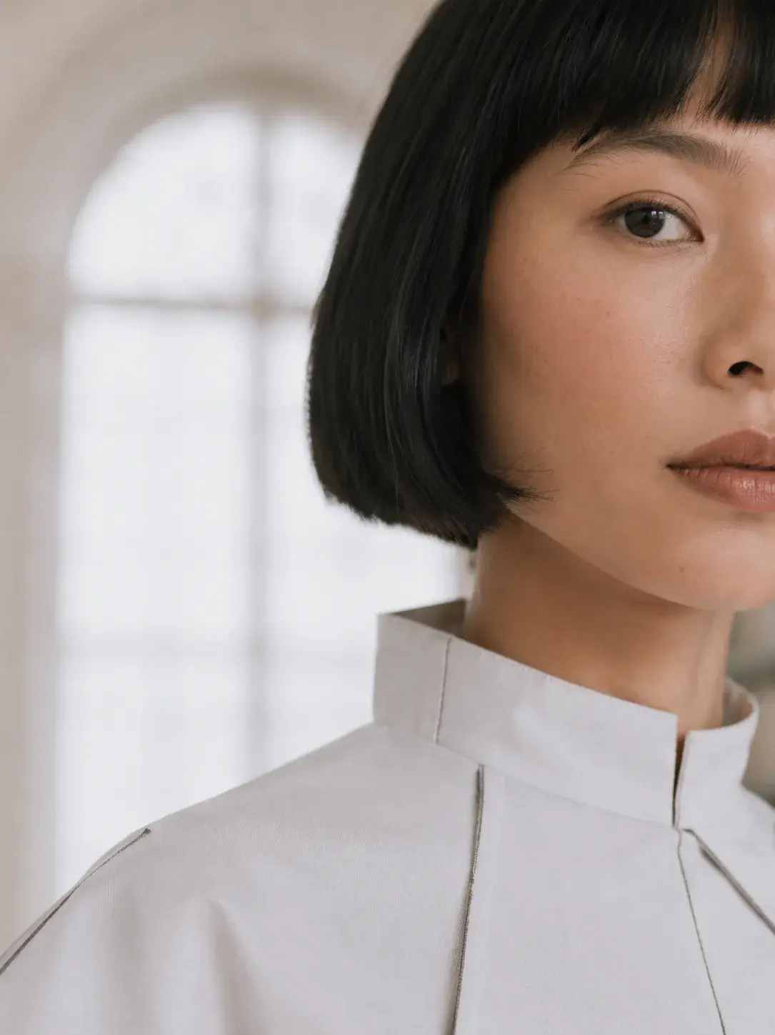 Très gros plan visage femme en col origami – beauté naturelle et lumière de fenêtre