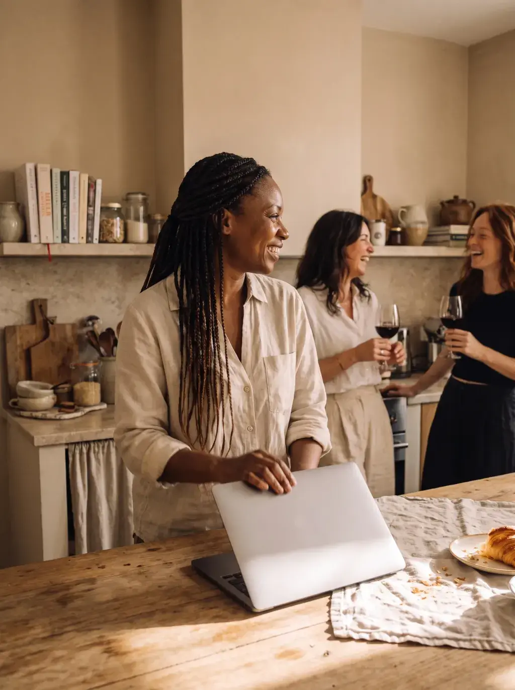 Trois femmes dans une cuisine chaleureuse entre vin et travail