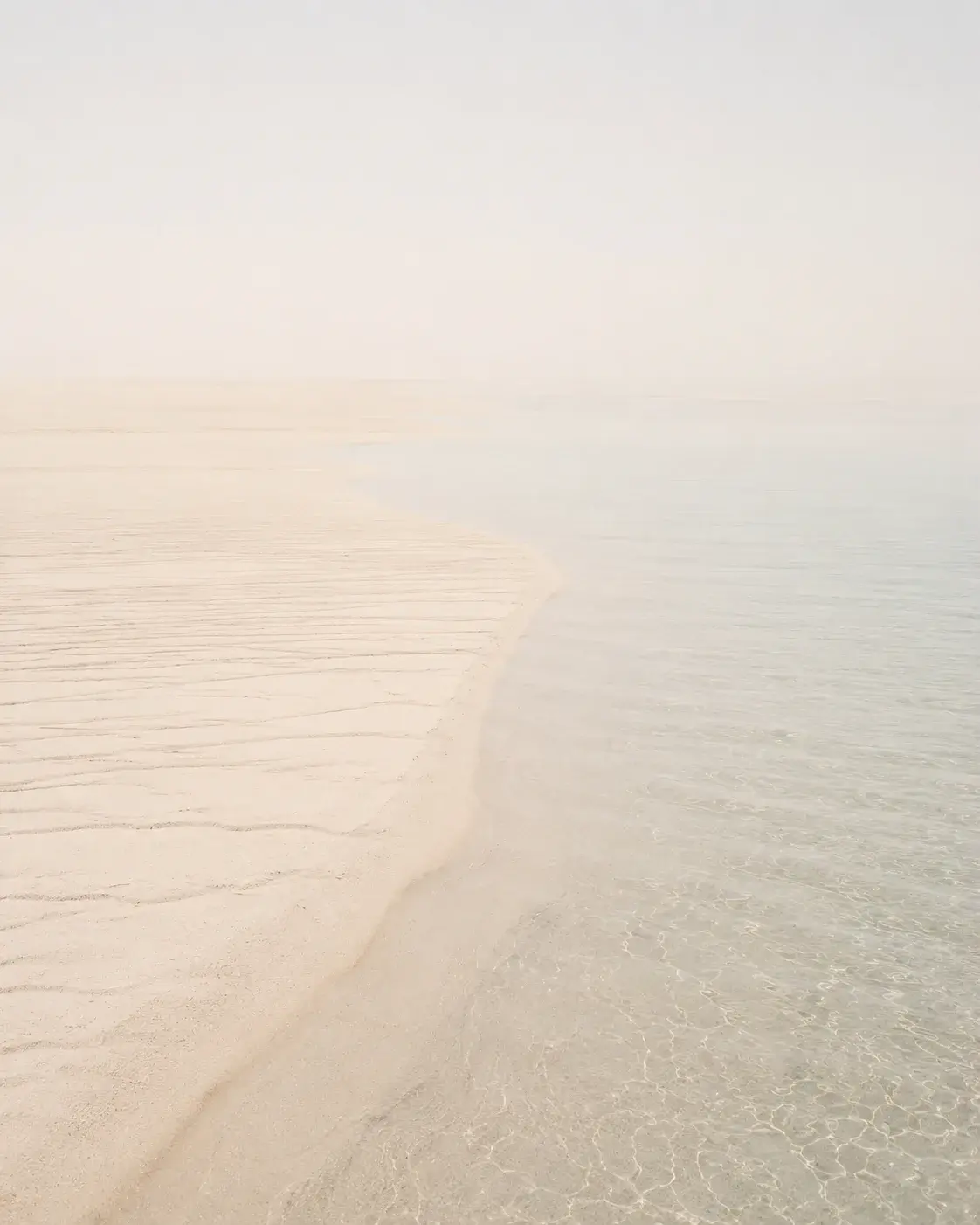 Vue aérienne d'un banc de sable rencontrant l'eau cristalline – composition minimaliste