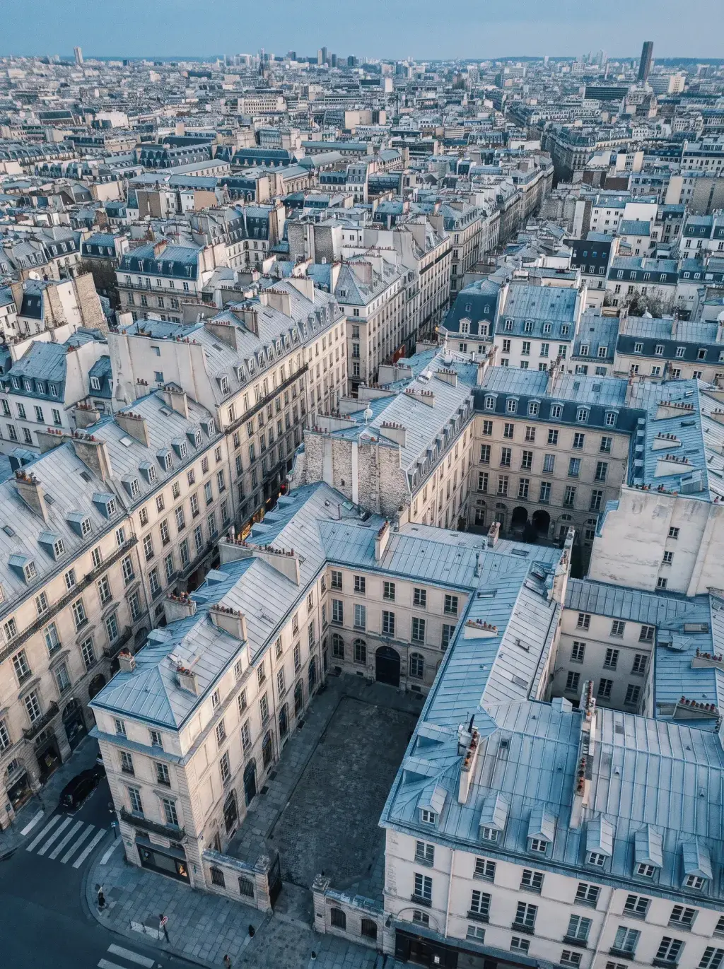 Vue aérienne des toits de Paris avec toitures en zinc, cheminées et patchwork haussmannien
