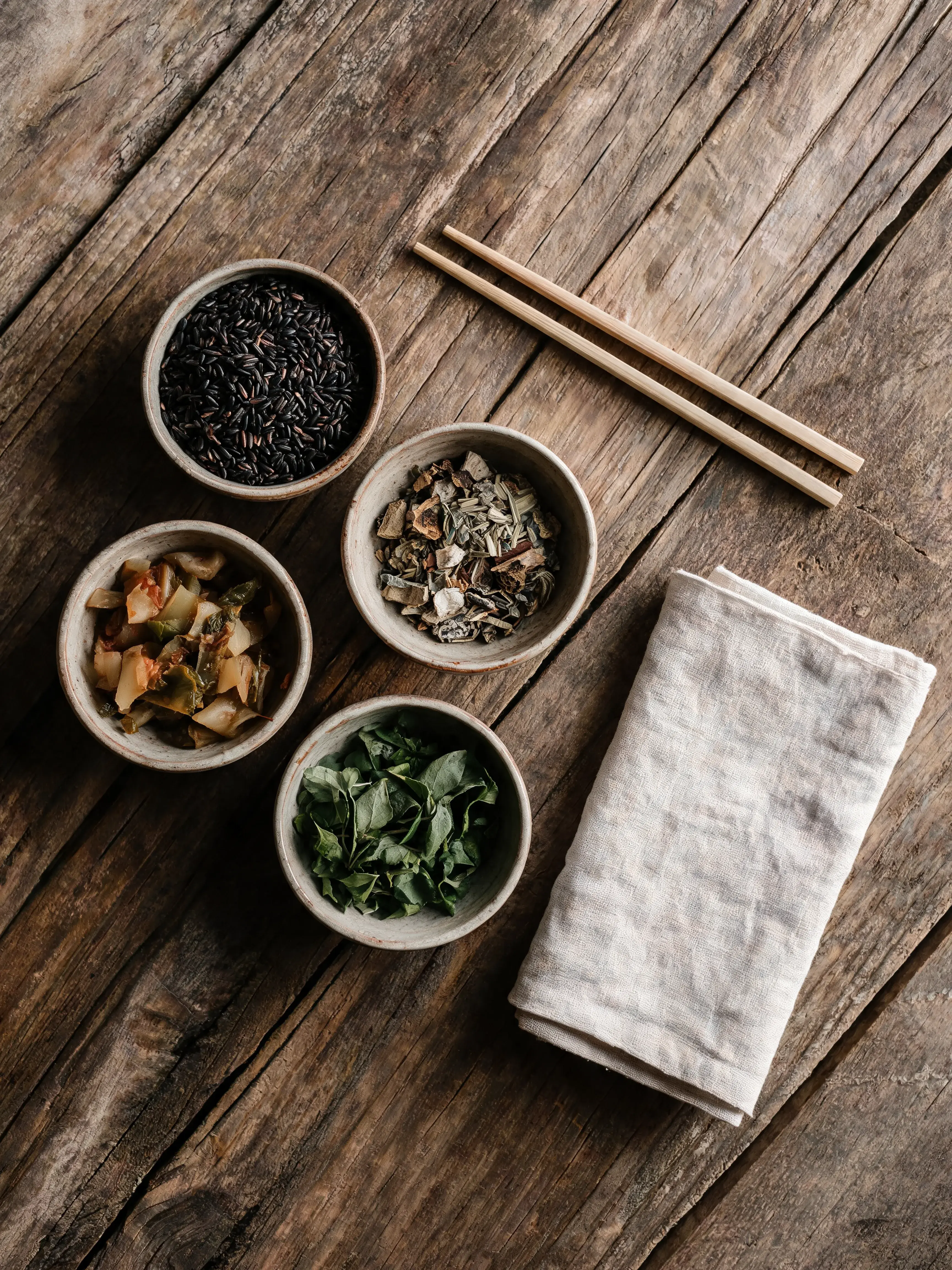 Vue de dessus – bols de condiments asiatiques sur table bois avec baguettes et serviette lin