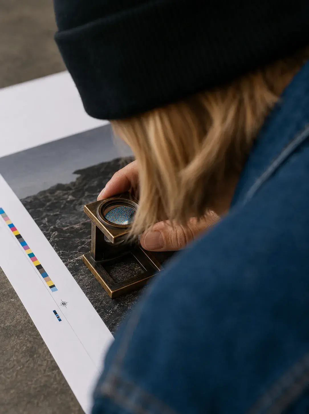 Vue plongeante – graphiste avec loupe, contrôle de maquette