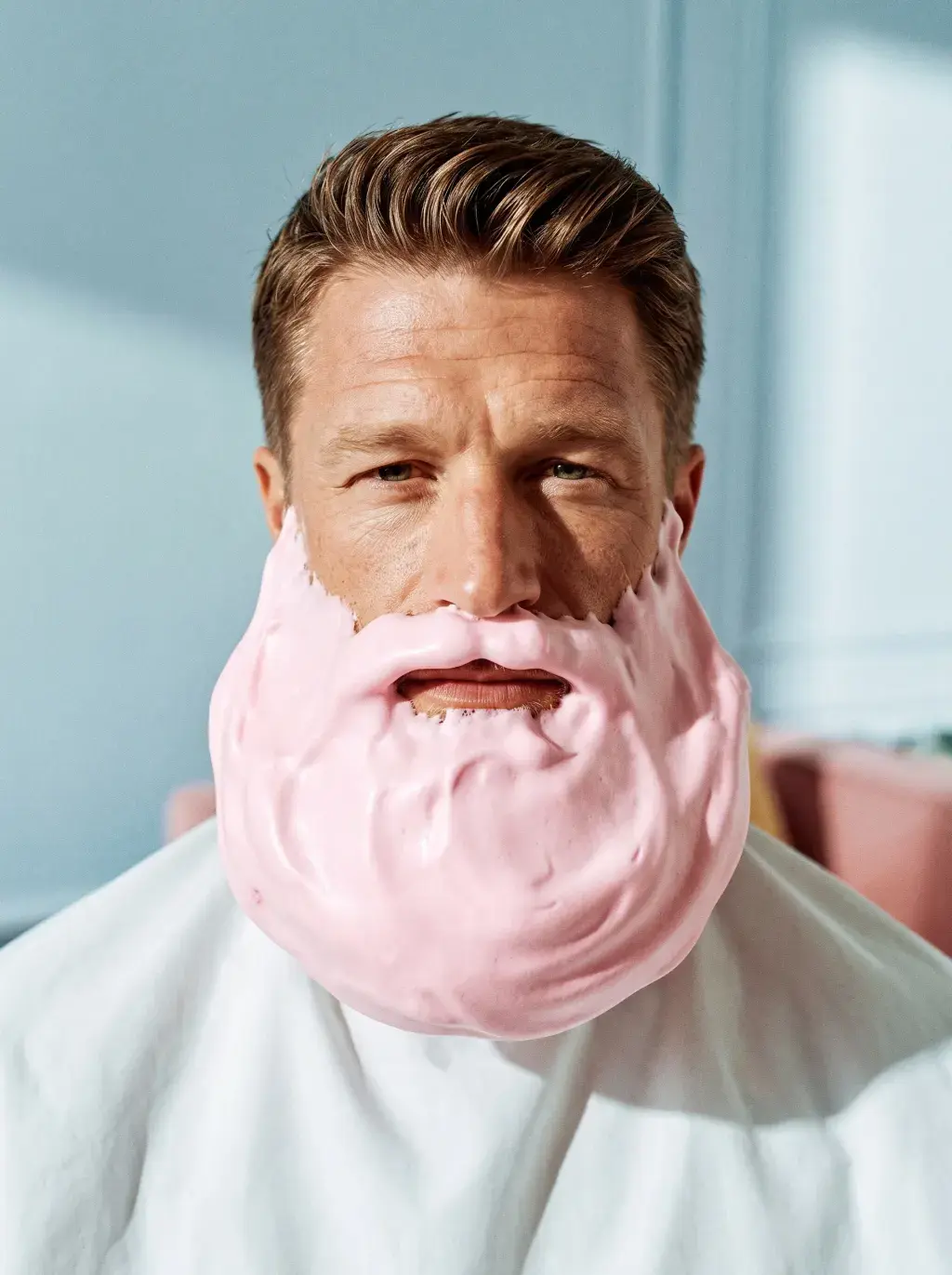 Portrait d'homme à la barbe recouverte de mousse à raser rose façon crème fouettée