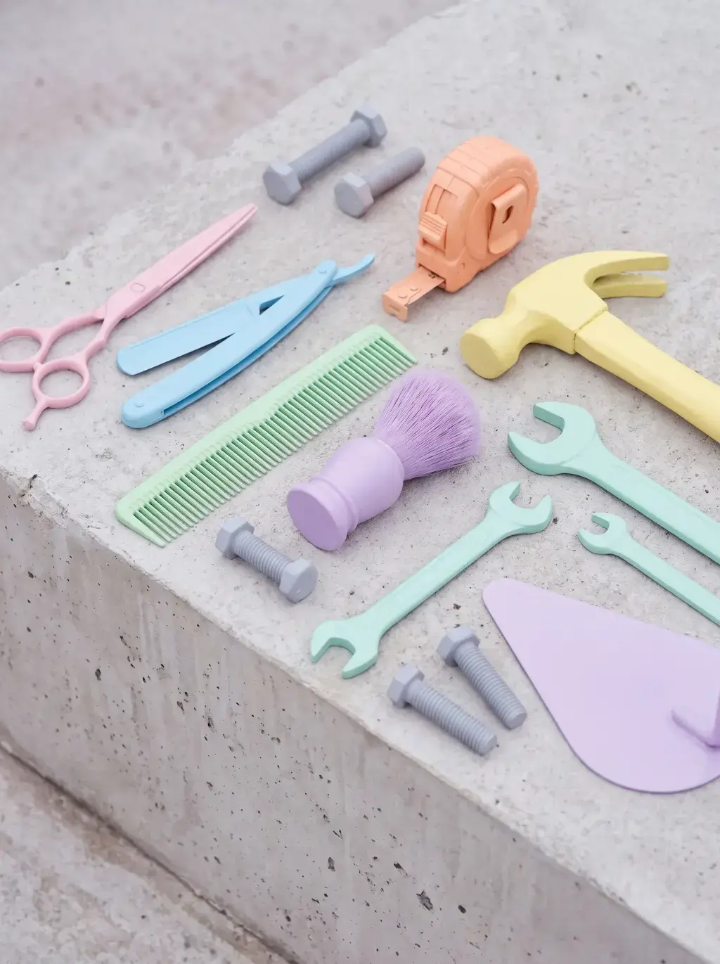 Flat lay d'outils de coiffure et de bricolage pastel, ciseaux, rasoir, clés et marteau