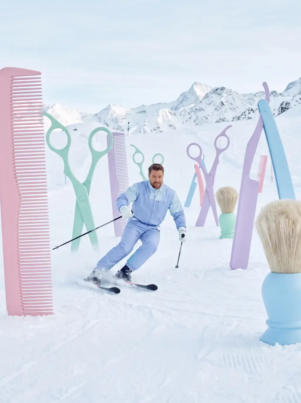 Homme skiant entre des sculptures géantes d'outils de coiffure pastel plantées dans la neige