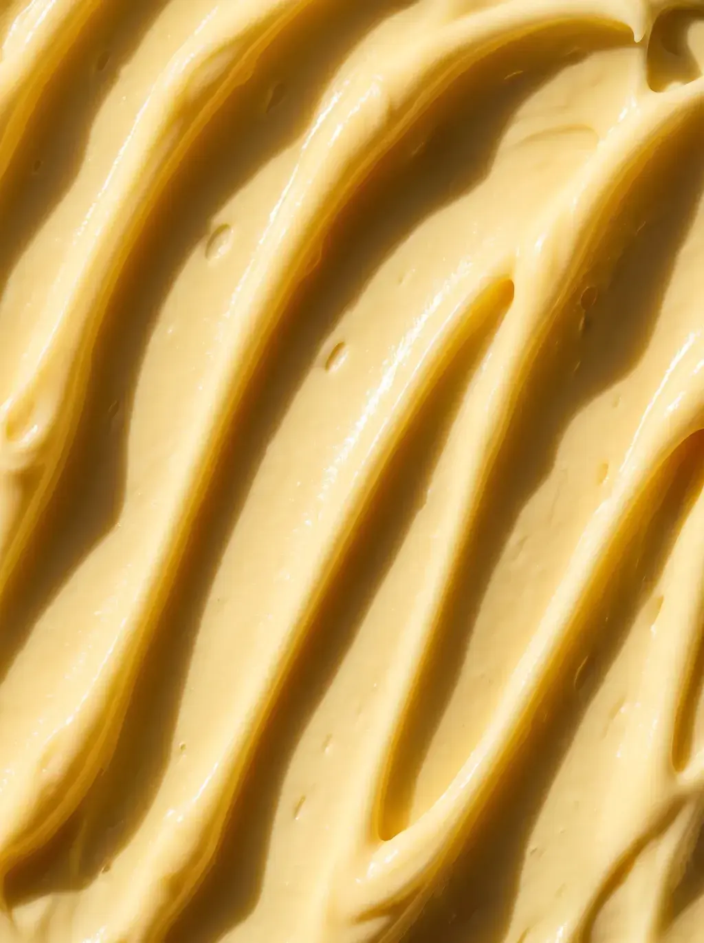 Macro de sillons ondulés creusés dans une crème cosmétique jaune