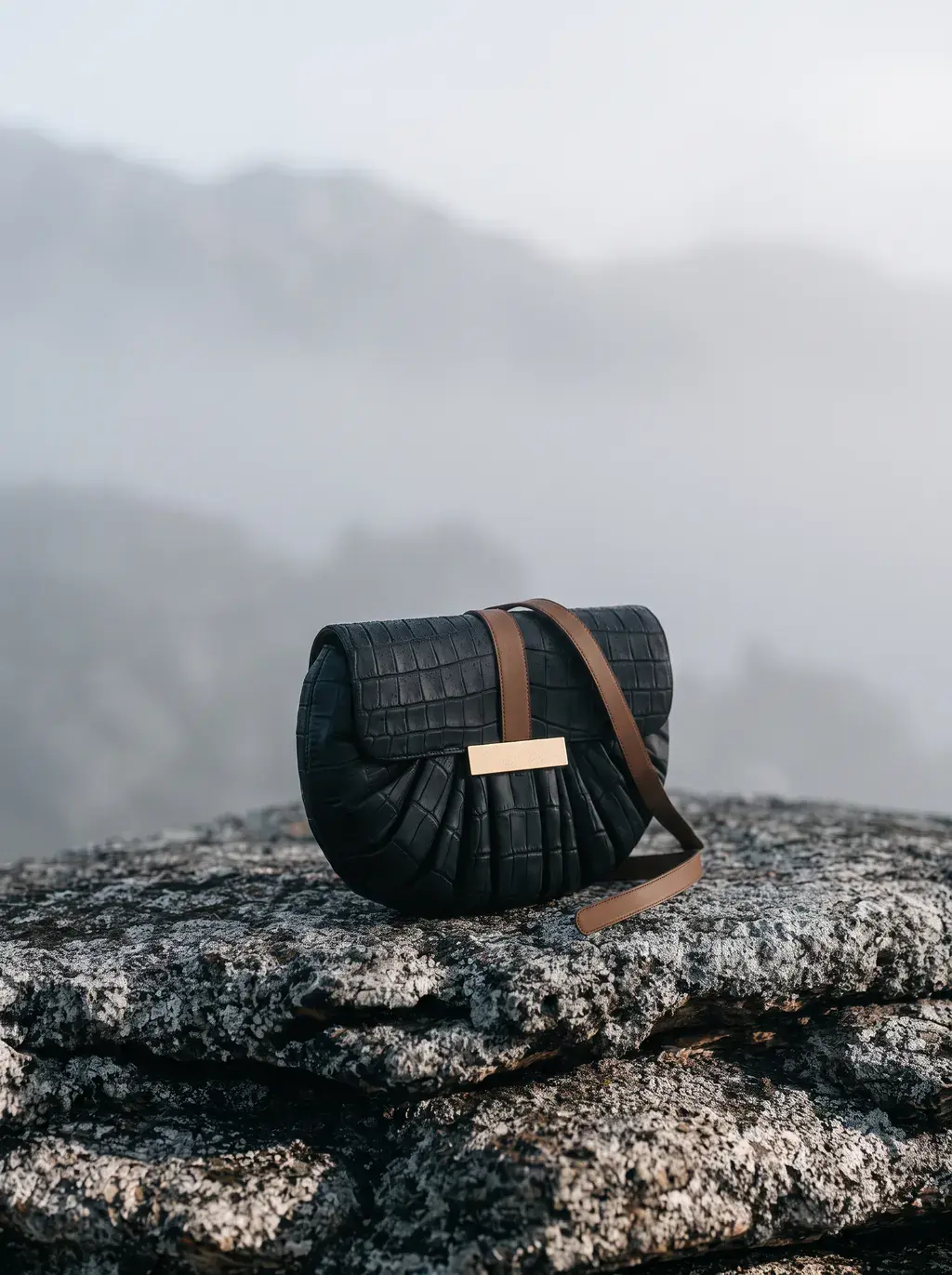 Sac à main sur rocher de montagne dans la brume matinale