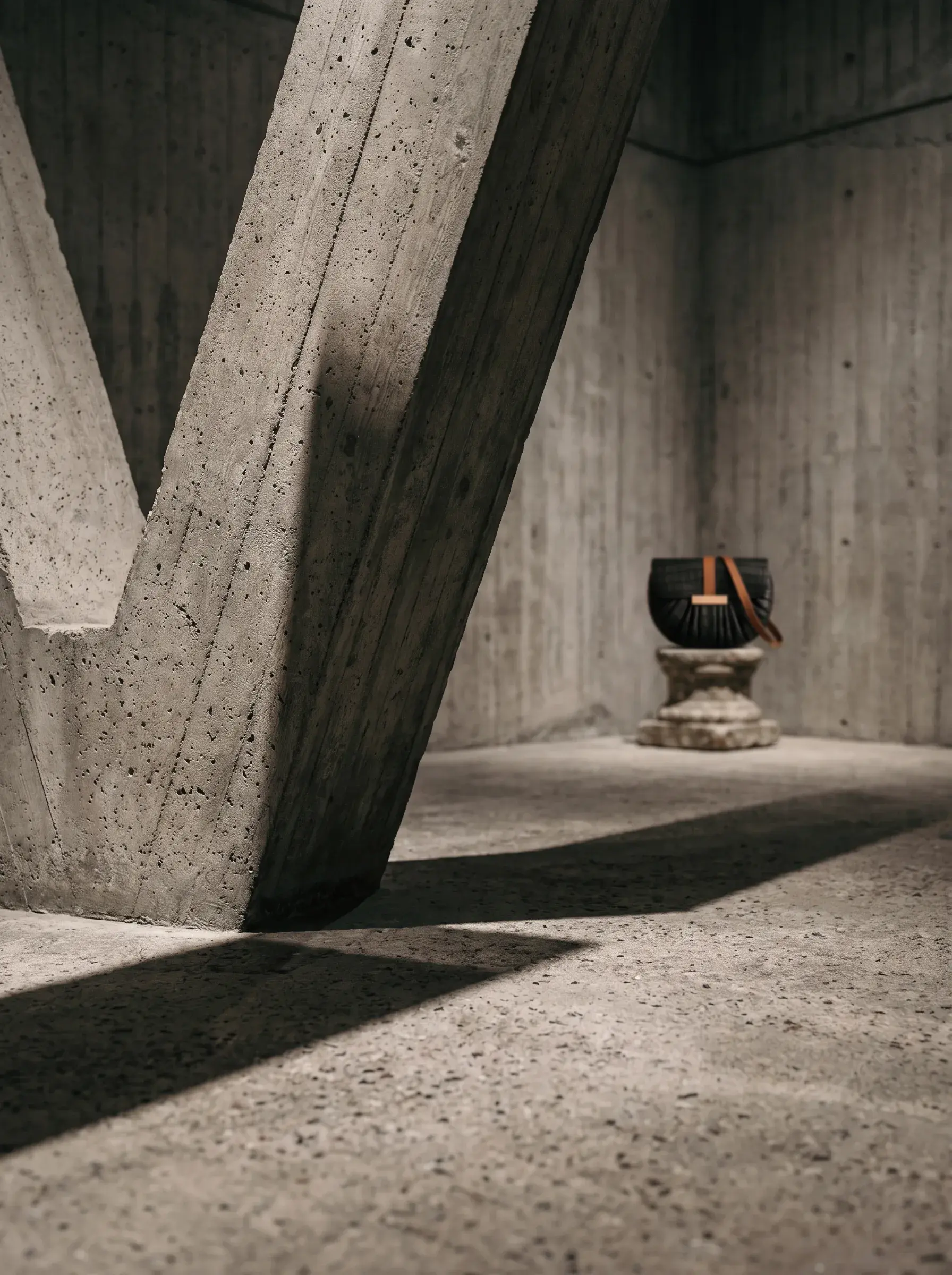 Petit sac noir exposé au loin dans une structure brutaliste monumentale