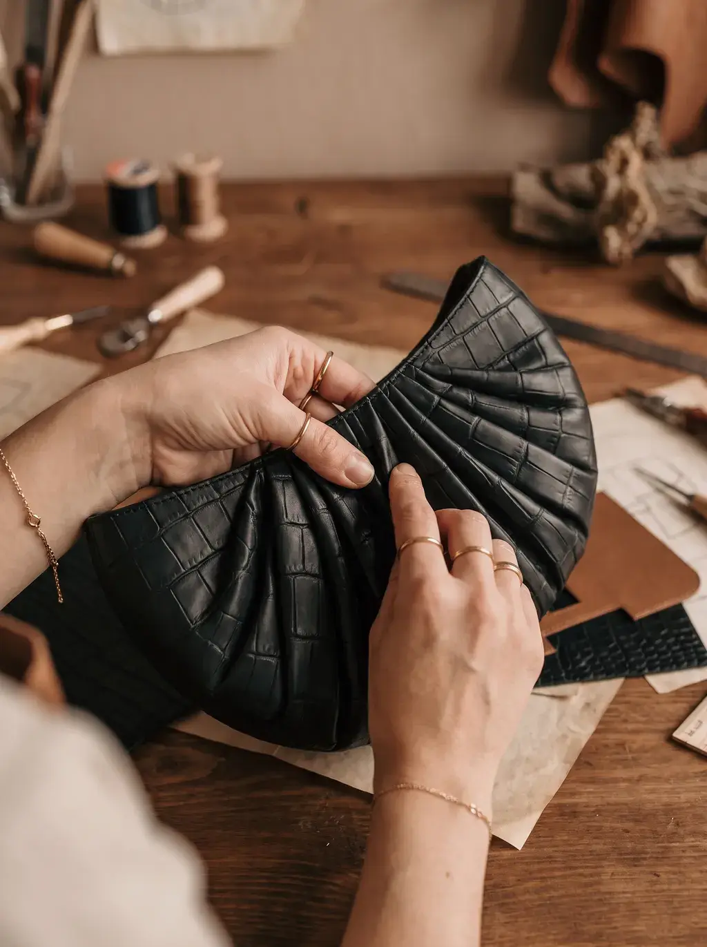 Mains façonnant le corps du sac croco avant assemblage final en atelier