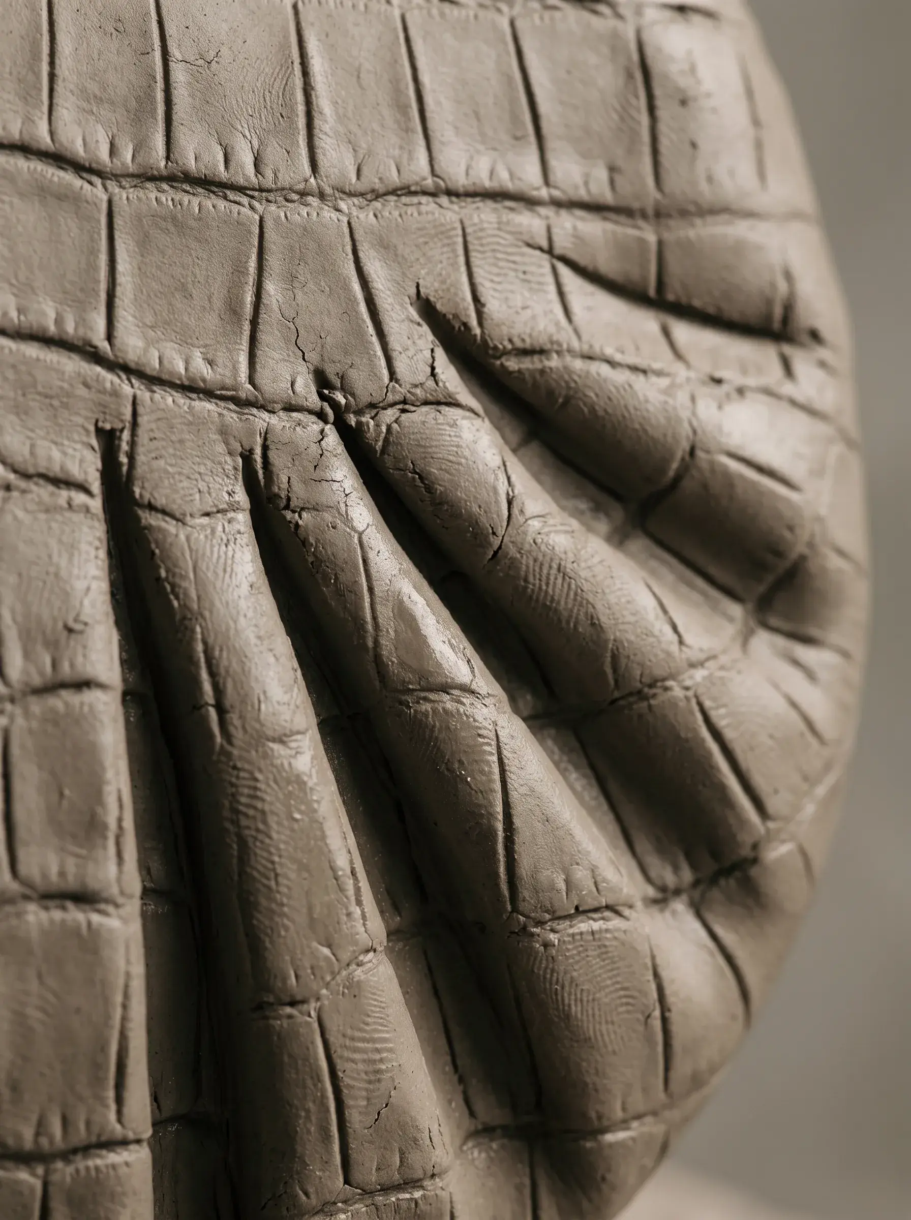 Prototype blanc de sac aux plis sculptés présenté contre un mur clair
