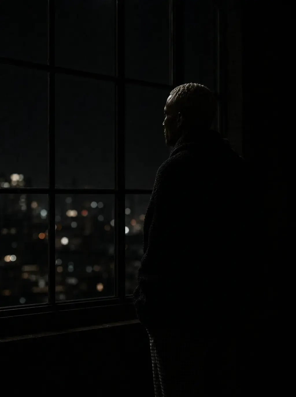 Silhouette artisan à la fenêtre — vue nocturne de la ville