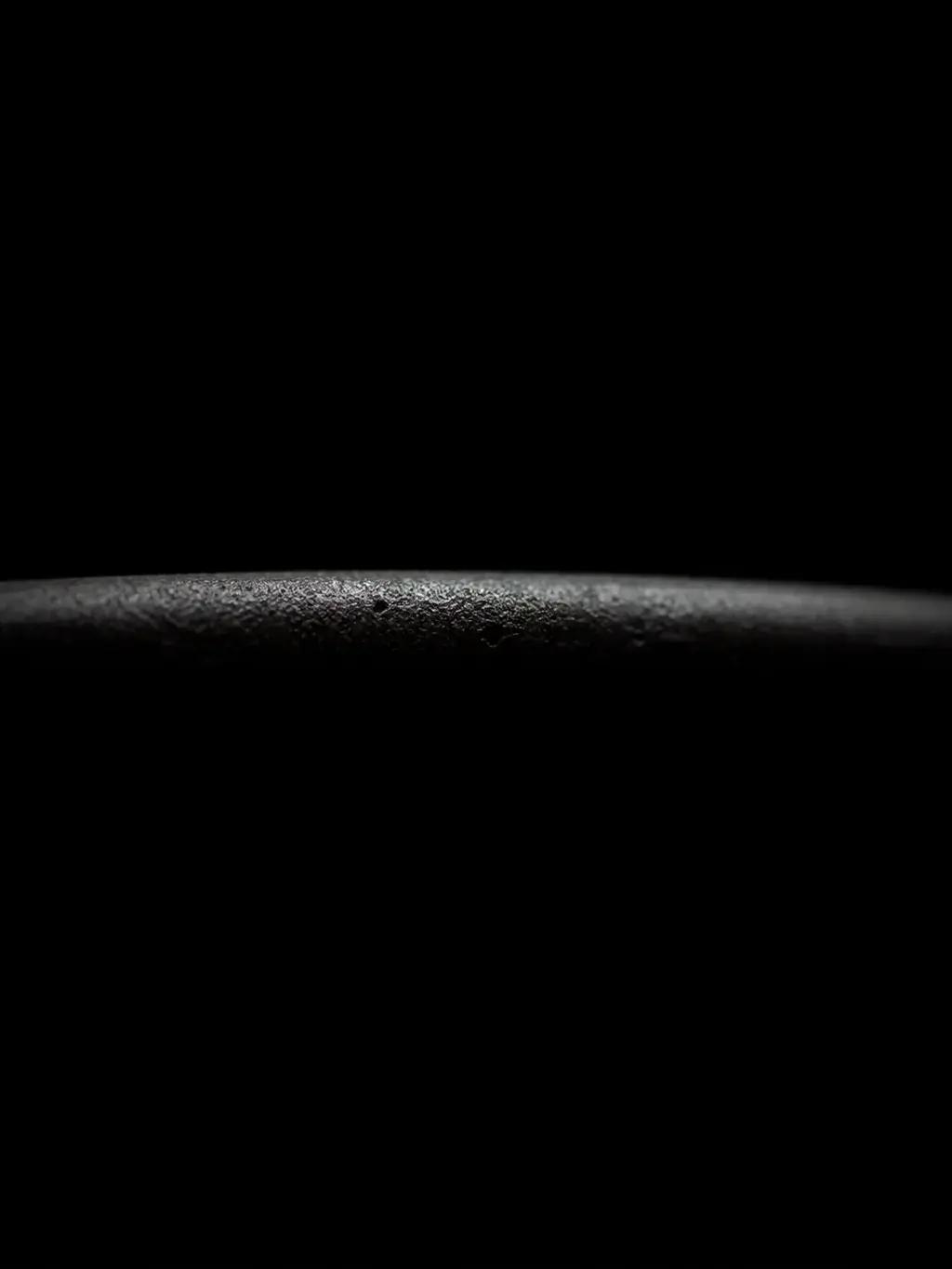 Macro du bord texturé d'un bol en céramique noire