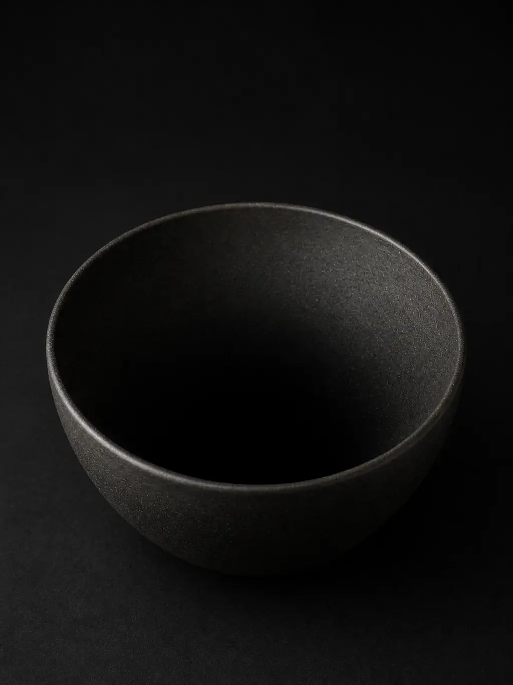 Grand bol hémisphérique en céramique noire sur fond sombre