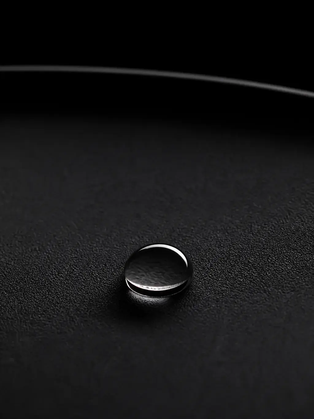Goutte d'eau isolée sur surface de céramique noire mate, macro